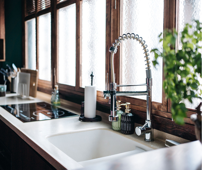 Sunlit kitchen with stainless steel faucet