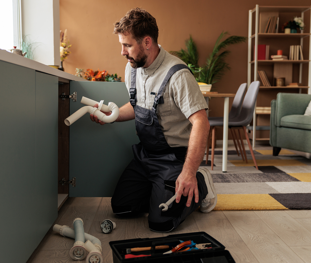 Man repairing under-sink plumbing